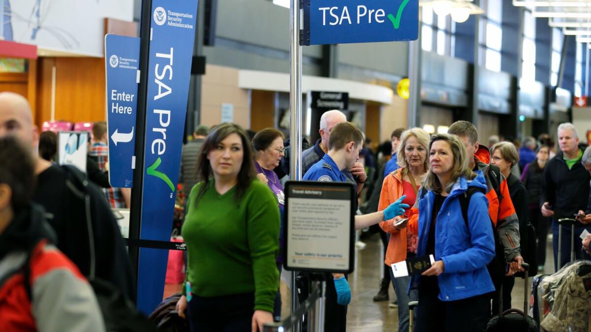 Travelers authorized to use the TSA PreCheck expedited security lines wait at Seattle-Tacoma International Airport. A study found that TSA doesn't have enough workers to meet its goal of enrolling 25 million travelers to TSA Precheck.