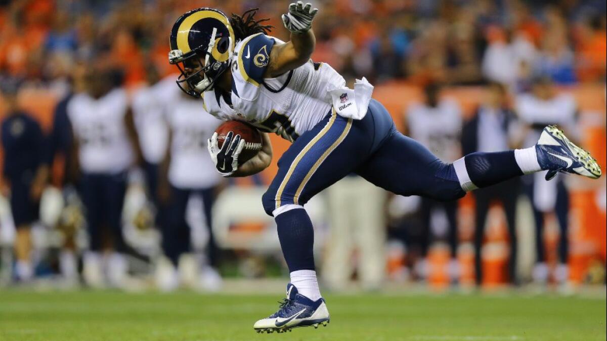 Rams running back Terrence Magee stumbles after taking a hit during his 73-yard run against the Broncos during an exhibition game on Aug. 27.