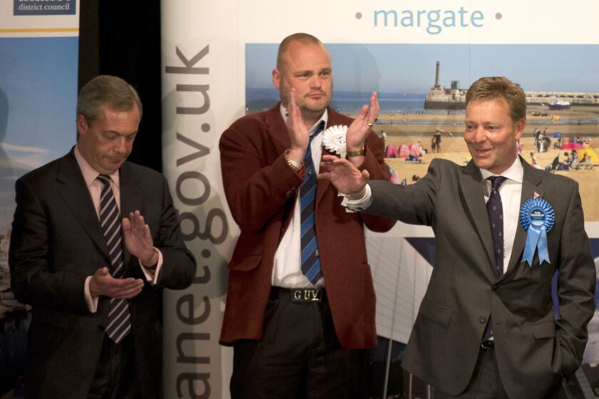 FILE - The Conservative Party's Craig Mackinlay, right, waves after winning the count for the South Thanet seat beside, from left, Nigel Farage the leader of the UK Independence Party (UKIP) and Al Murray a comedian who performs as "The Pub Landlord" at the Winter Gardens in Margate, south east England, on May 8, 2015. Conservative legislator Craig Mackinlay was returning to work on Wednesday, six months after sepsis put him in a coma and forced the amputation of his hands and feet. (AP Photo/Matt Dunham, File)
