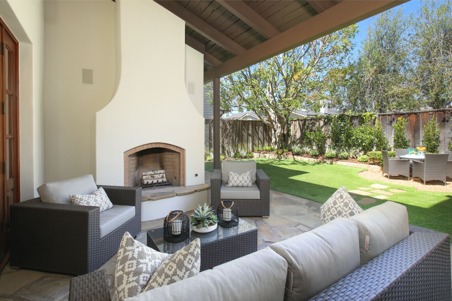 The backyard has a patio with fireplace and a turf lawn.