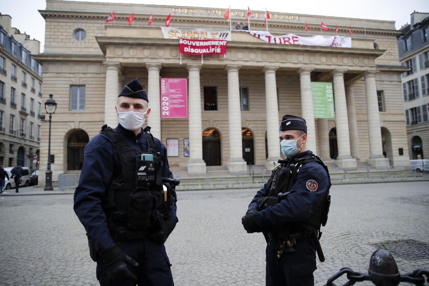 Police officers stand outside the occupied iconic Odeon theater, Friday, March 5, 2021 in Paris. Out-of-work French culture and tourism workers have occupied the theater on Paris' Left Bank to demand more government support after a year of pandemic that has devastated their livelihoods. (AP Photo/Francois Mori)