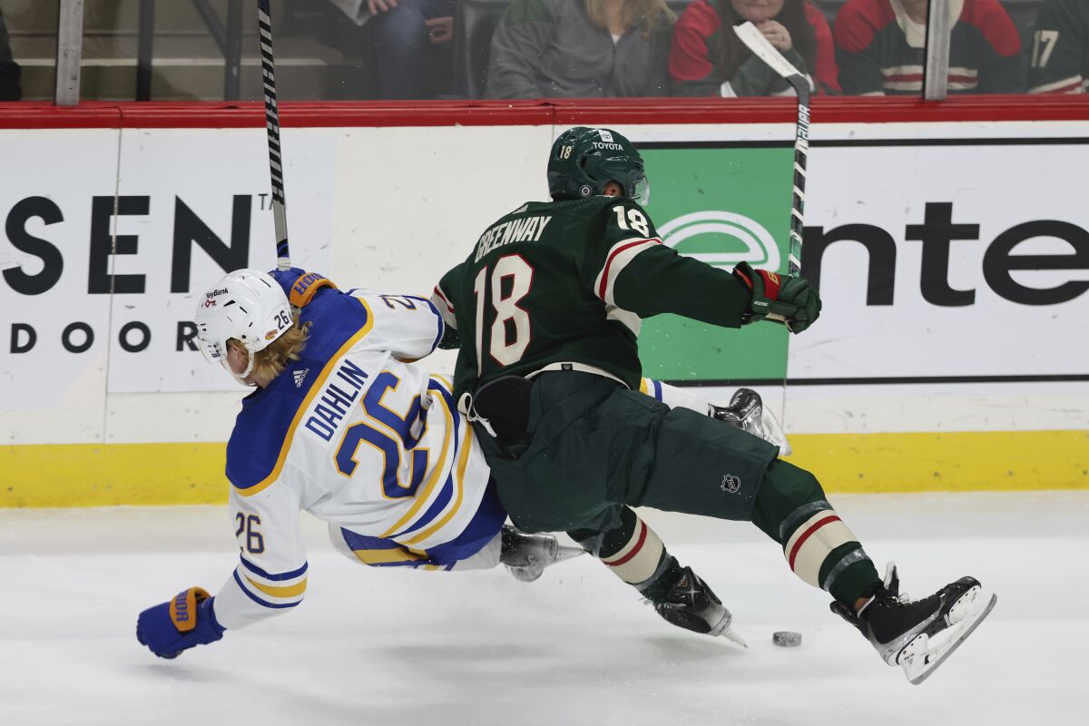 Minnesota Wild left wing Jordan Greenway (18) collides with Buffalo Sabres defenseman Rasmus Dahlin (26) during the first period of an NHL hockey game, Thursday, Dec. 16, 2021, in St. Paul, Minn. (AP Photo/Stacy Bengs)