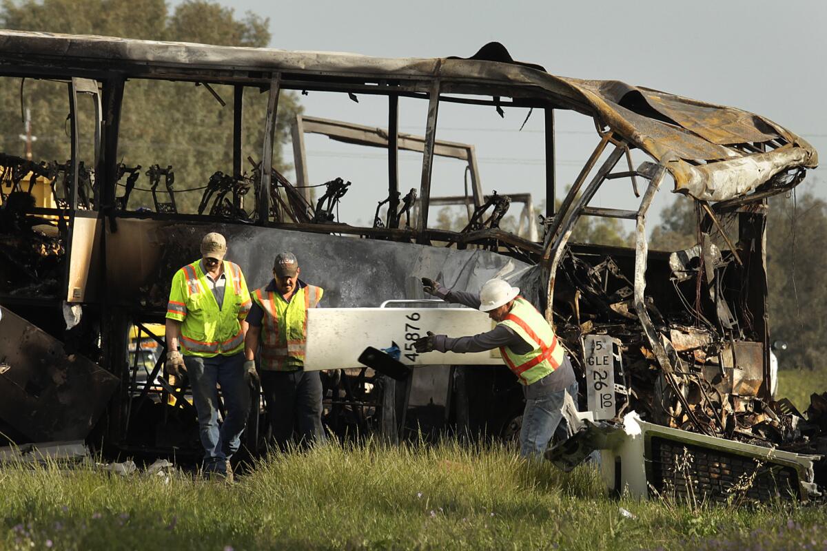 Workers survey the remnants of a bus that was struck in April 2014 by a FedEx truck along Interstate 5 near Orland. The bus was carrying several high school students from Los Angeles.