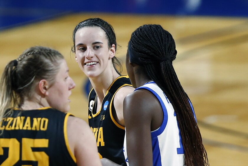 FILE - Iowa guard Caitlin Clark, center, smiles at Kentucky guard Rhyne Howard, right, after she was fouled during the second half of a college basketball game in the second round of the women's NCAA tournament at the Greehey Arena in San Antonio, Tuesday, March 23, 2021. A COVID-19 outbreak that put the Iowa women's basketball season on pause cost the Hawkeyes a chance to play two games in Cancun. “Definitely glad it happened now rather than in March or another time when we would have to cancel games in the Big Ten season,” Clark said. (AP Photo/Ronald Cortes, File)