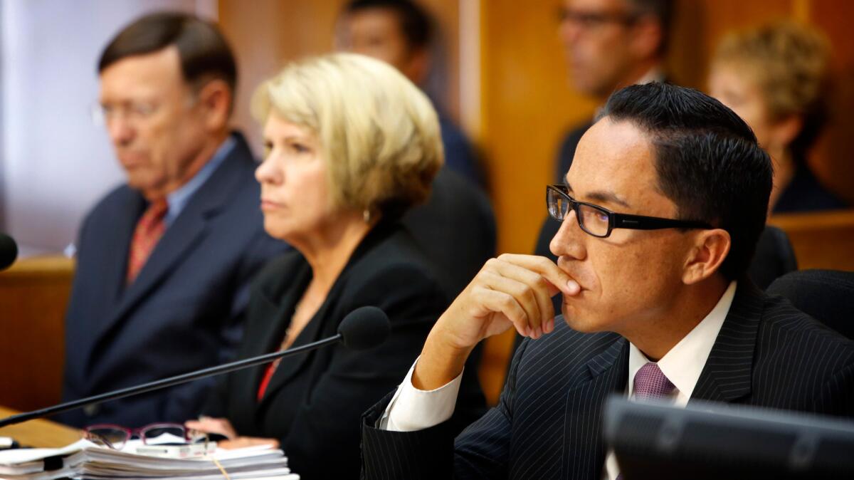 Former San Diego City Council President Todd Gloria, right, listens to public comment about former Mayor Bob Filner during a special meeting in the council chambers in San Diego on Aug. 23, 2013.