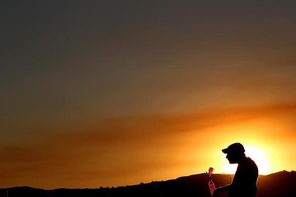 A spectator watches water-dropping helicopters