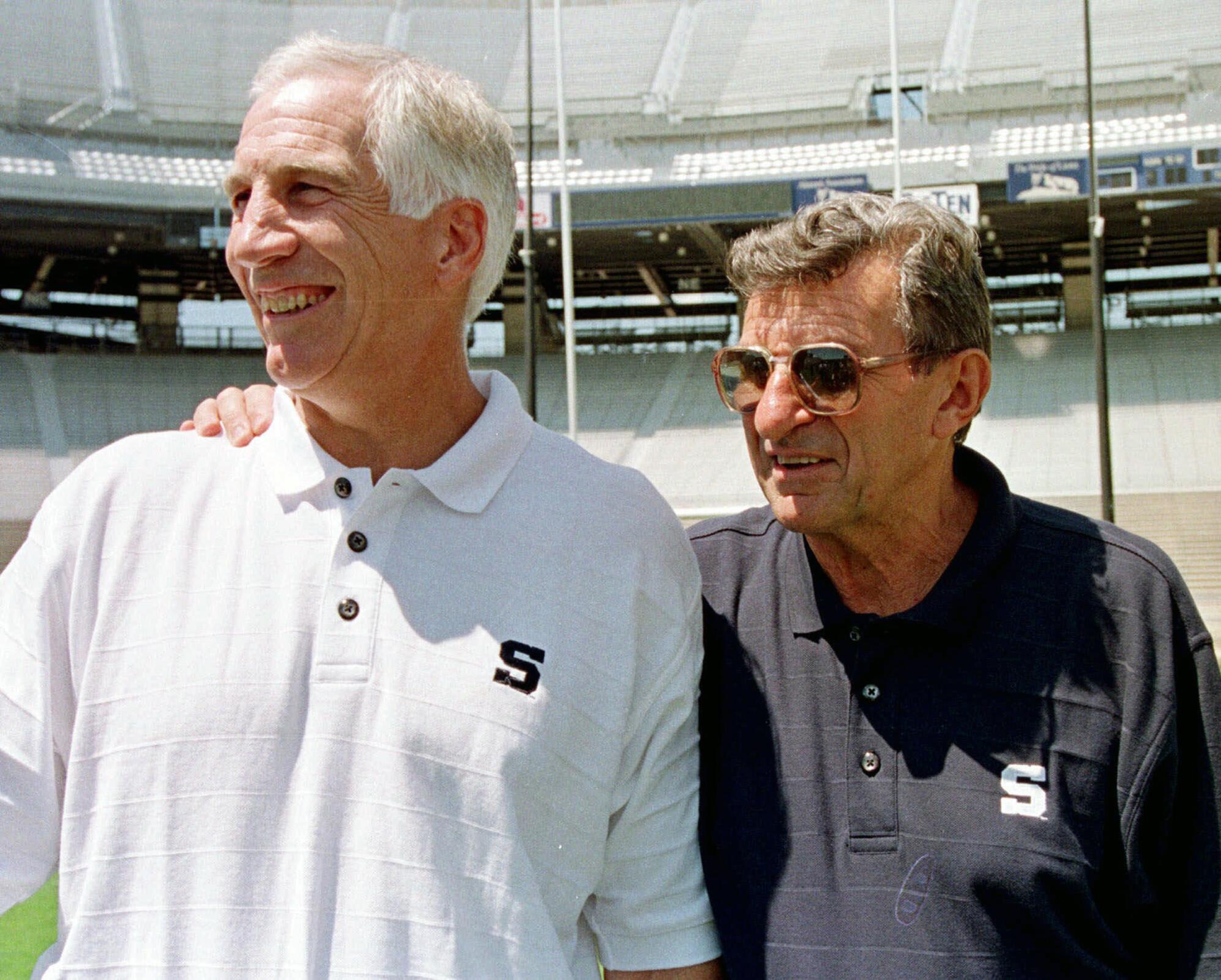 Penn State coach Joe Paterno, right, poses with his arm around defensive coordinator Jerry Sandusky in 1999.