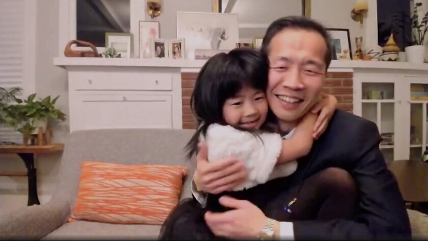 "Minari" writer-director Lee Isaac Chung gets a hug from his daughter, Livia, in a living room.