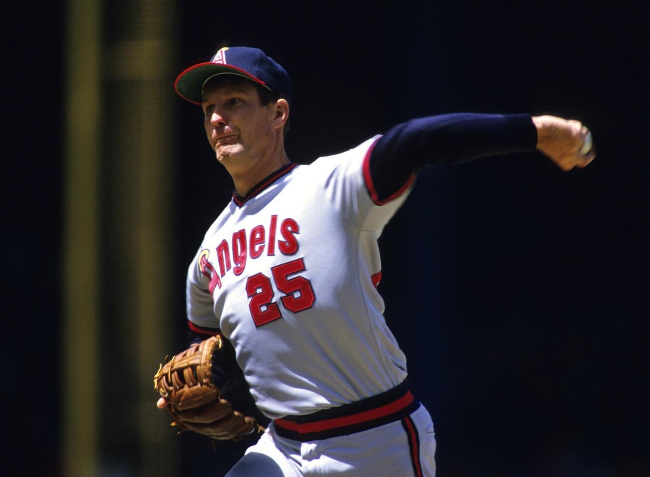 Dr. Frank Jobe transplanted an elbow ligament in Tommy John's throwing arm in 1974. John is seen pitching for the Angels in 1984. He retired in 1989, with more than half of his wins coming after the surgery.