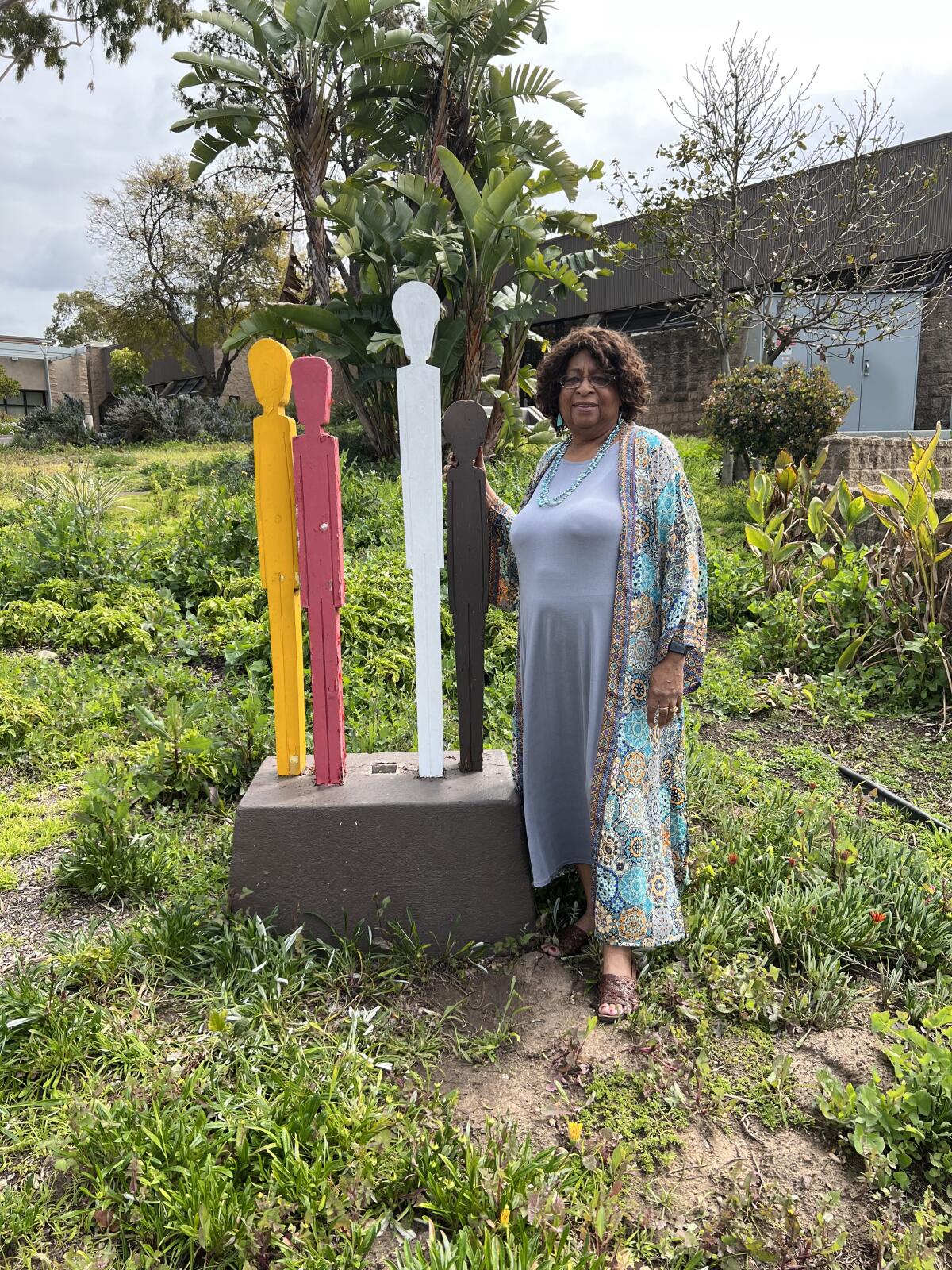 Carole Wade Boyce stands next to a statue at the San Diego College of Continuing Education’s Educational Cultural Complex