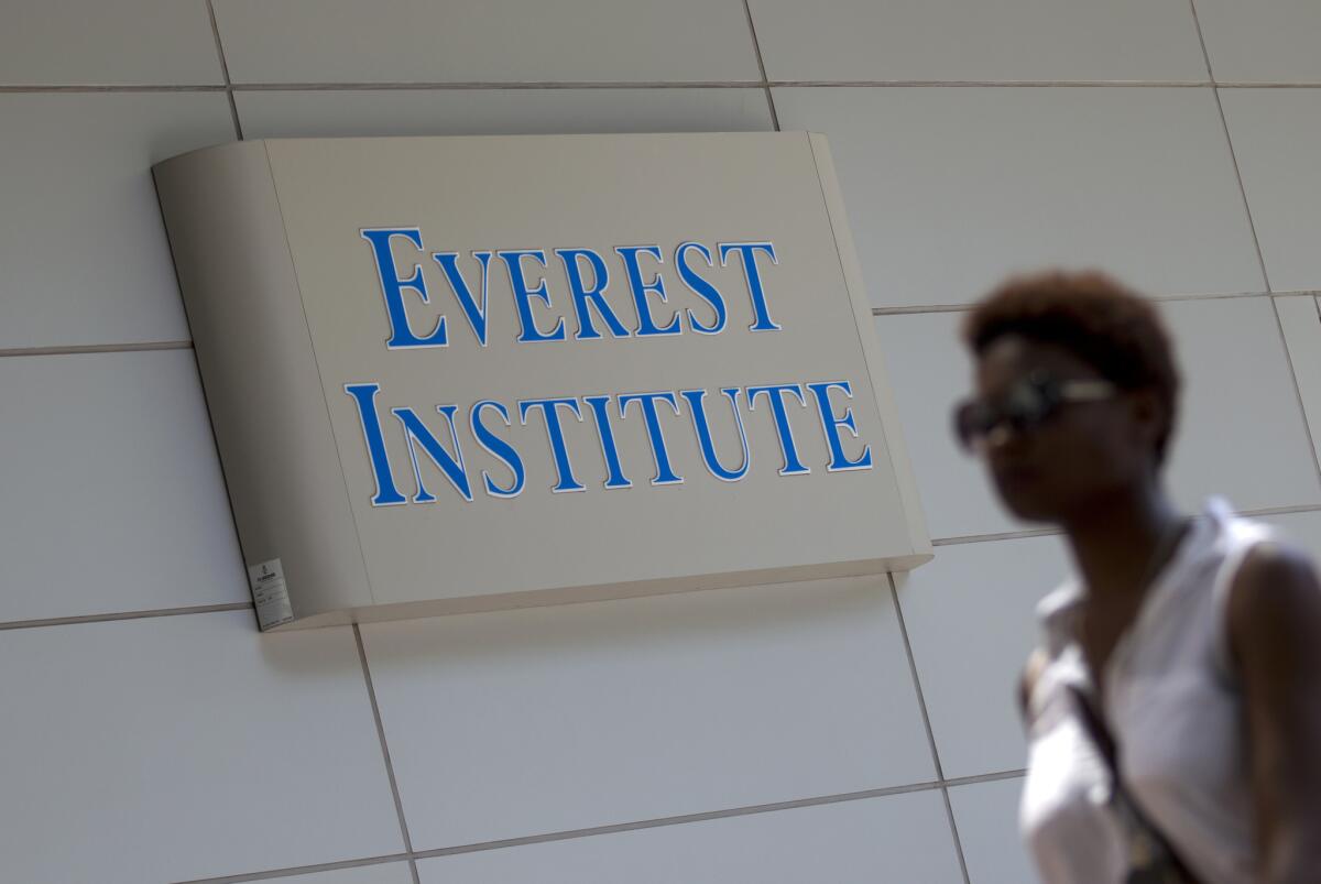 A person walks past an Everest Institute sign in Silver Spring, Md., in July. Nasdaq moved to delist Corinthian Colleges from the stock exchange after the company has failed to file required quarterly financial reports.