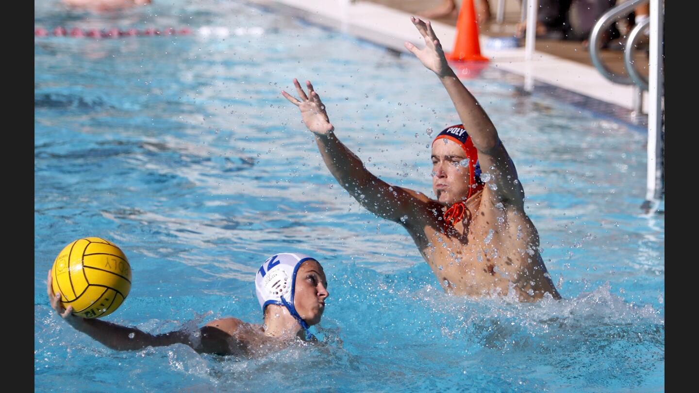 Flintridge Prep boys water polo player #12 Ryan Huntley takes a point-blank shot on goal for a score in away game vs. Poly High School goalie Oliver Penner in Pasadena on Wednesday, Sept. 27, 2017.