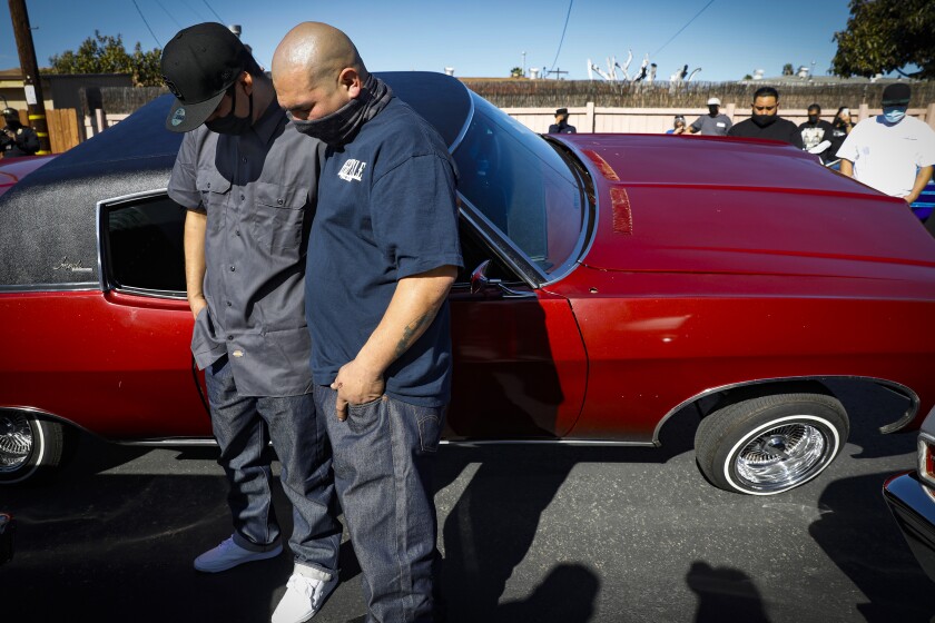 Jose Guadarrama, left, whose father just passed await from COVID-19, is comforted by Isaac Llamas