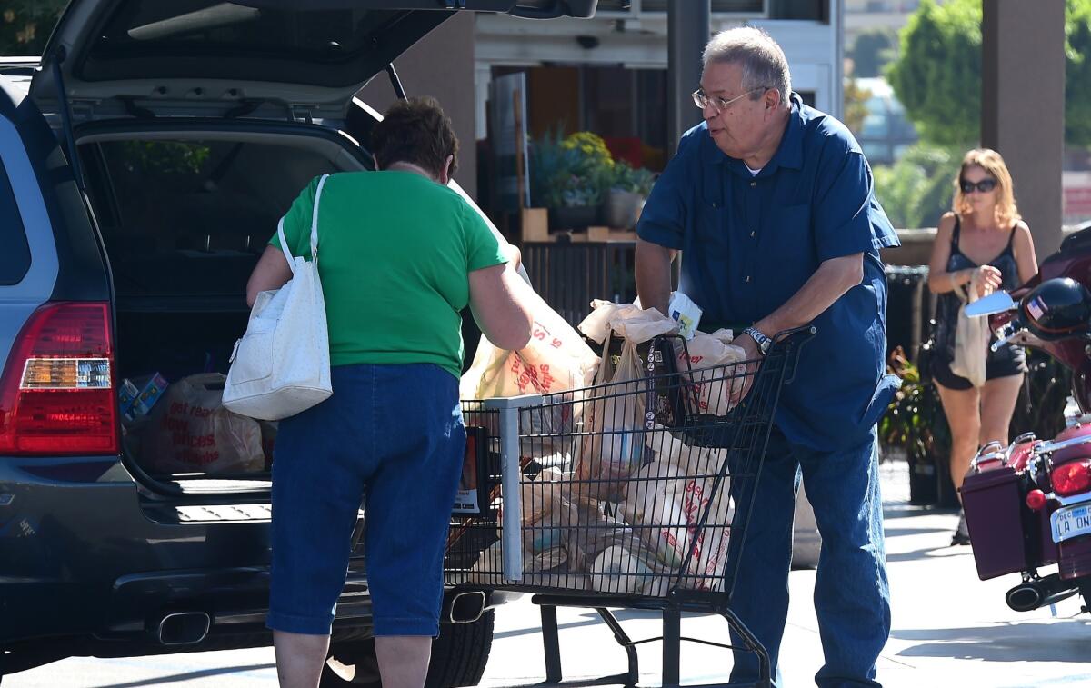 Shoppers transfer groceries from a supermarket cart into their car in Monterey Park, California in September.