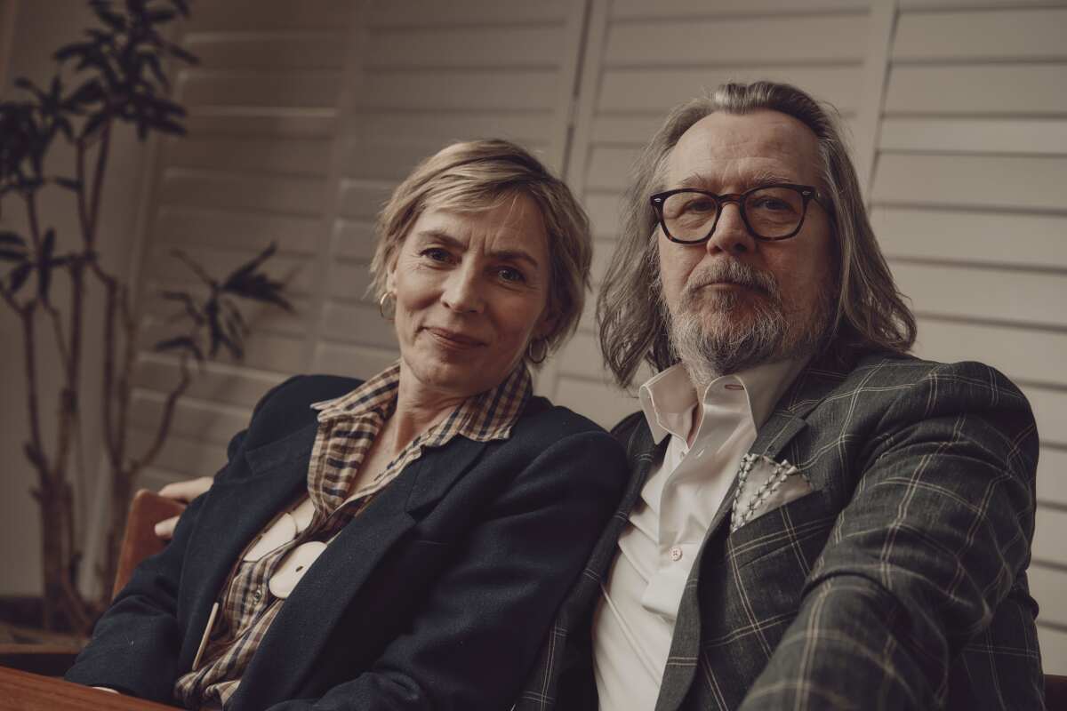 Saskia Reeves and Gary Oldman sit close together for a portrait.