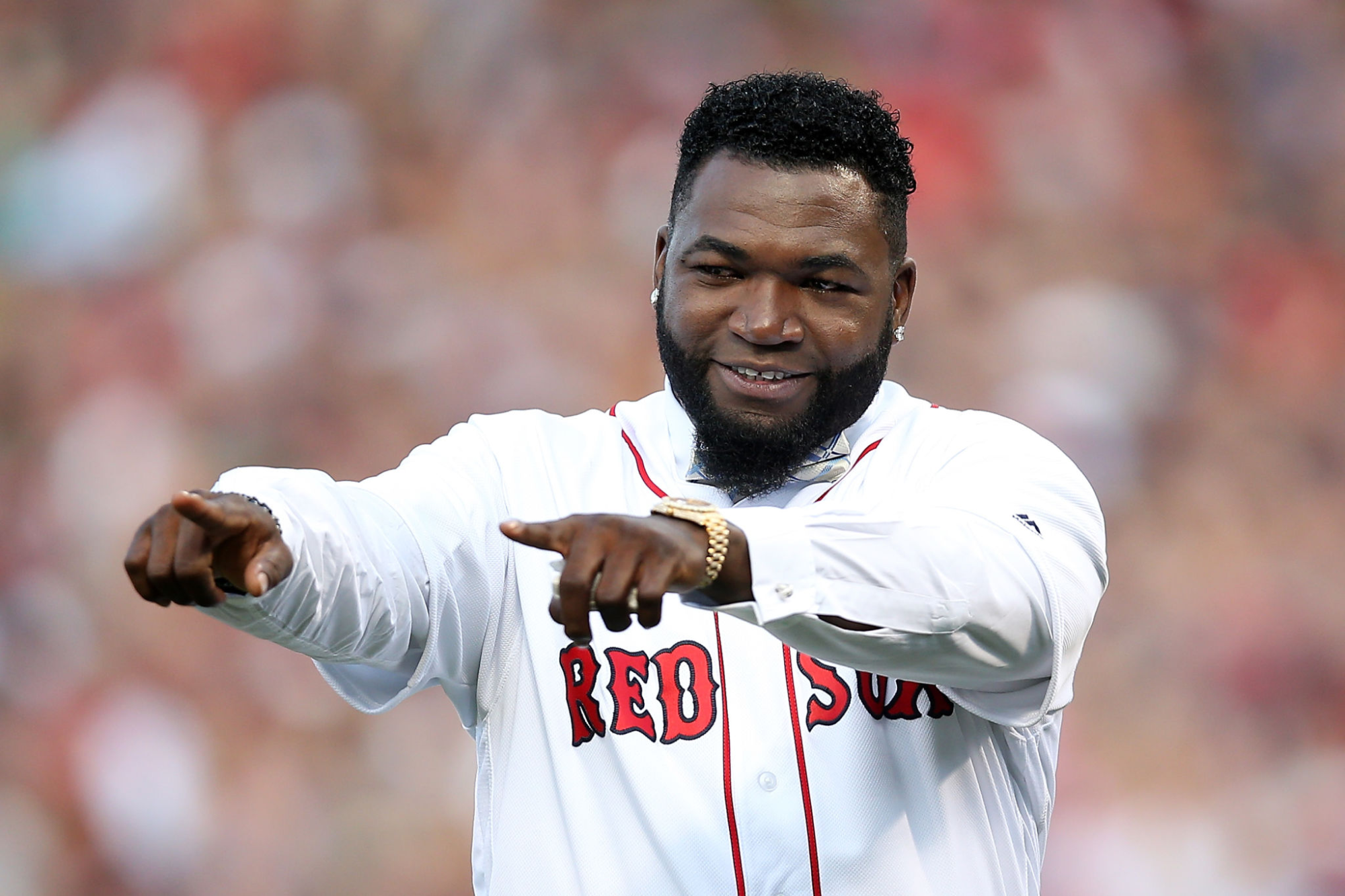 Former Boston Red Sox player David Ortiz points and smiles during his jersey retirement ceremony.