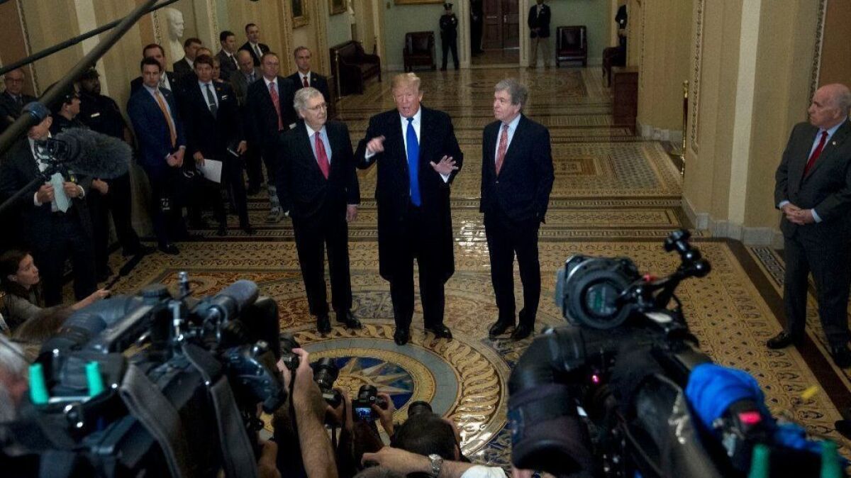 President Trump, flanked by Senate Majority Leader Mitch McConnell, left, and Sen. Roy Blunt, talks to reporters as he arrived for Senate Republicans' weekly lunch Tuesday.