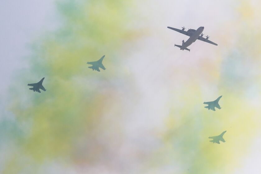 Chinese military planes fly in formation over a trail colored smoke in Beijing, Sunday, Sept. 22, 2019. Many of the streets in the central part of China's capital were shut down over the past weekend for a rehearsal for what is expected to be a large military parade on Oct. 1 to commemorate the 70th anniversary of Communist China.