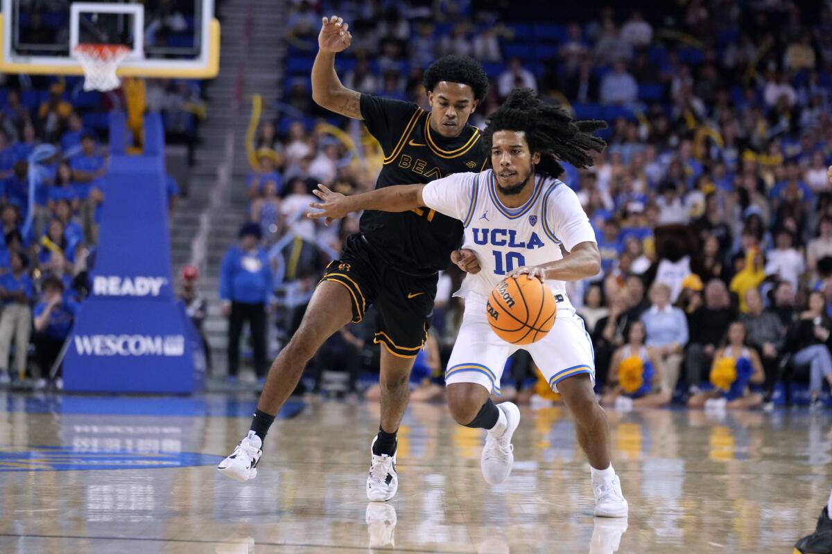 UCLA guard Tyger Campbell drives against Long Beach State's Tone Hunter on Nov. 11, 2022.