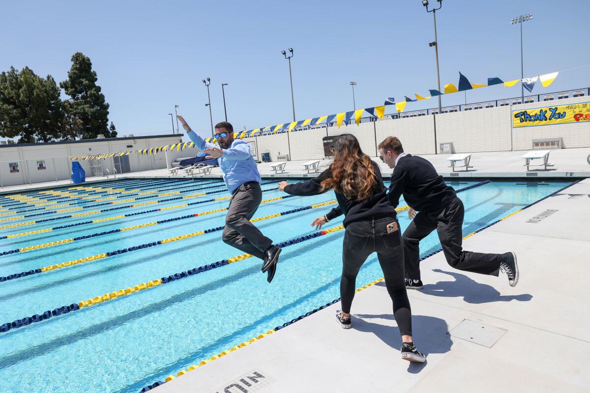 Marina High Principal Morgan Smith is pushed into the new pool at Wednesday's ribbon-cutting ceremony.