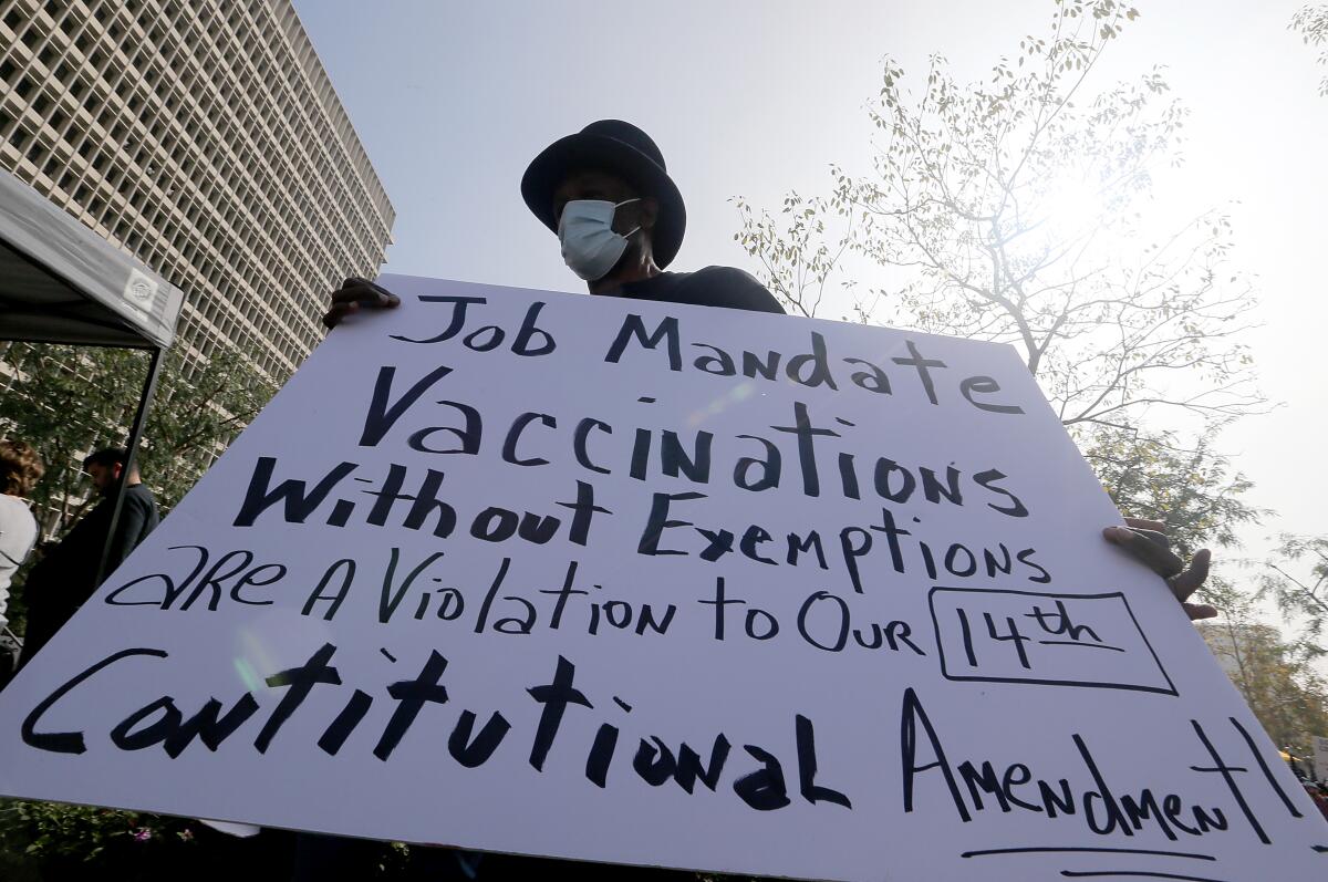 A man protests vaccination mandates  at Grand Park downtown