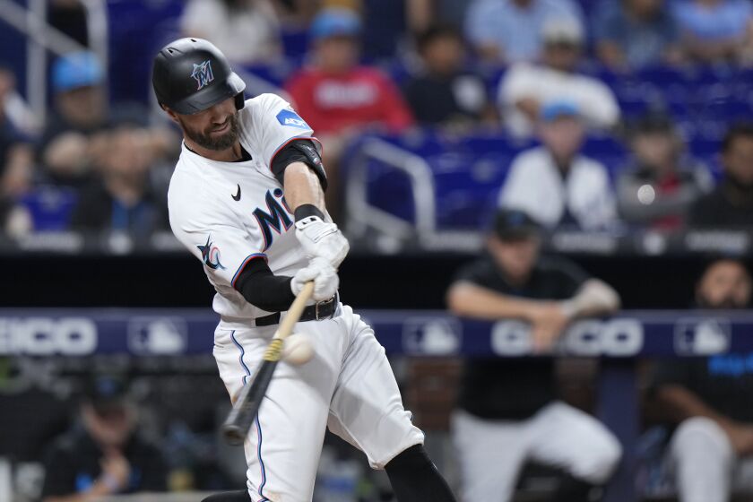 Miami Marlins' Jon Berti hits a triple scoring Nick Fortes and Joey Wendle during the fourth inning of a baseball game against the Kansas City Royals, Monday, June 5, 2023, in Miami. (AP Photo/Wilfredo Lee)