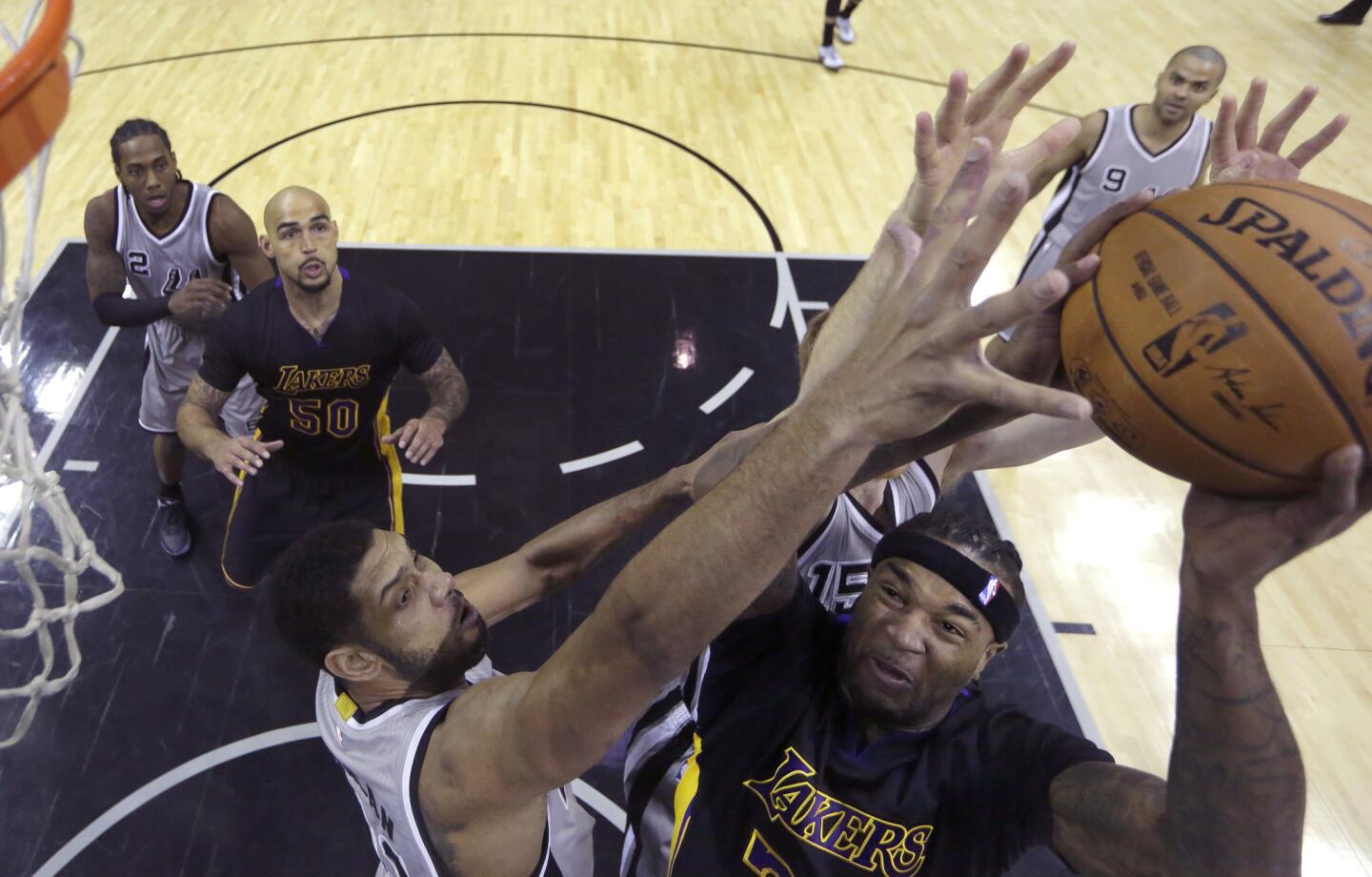 Lakers center Jordan Hill tries to power his way to the basket against Spurs forward Tim Duncan in the second half.