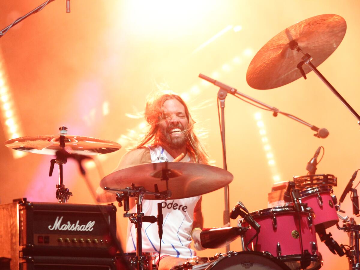 A man with long hair playing drums