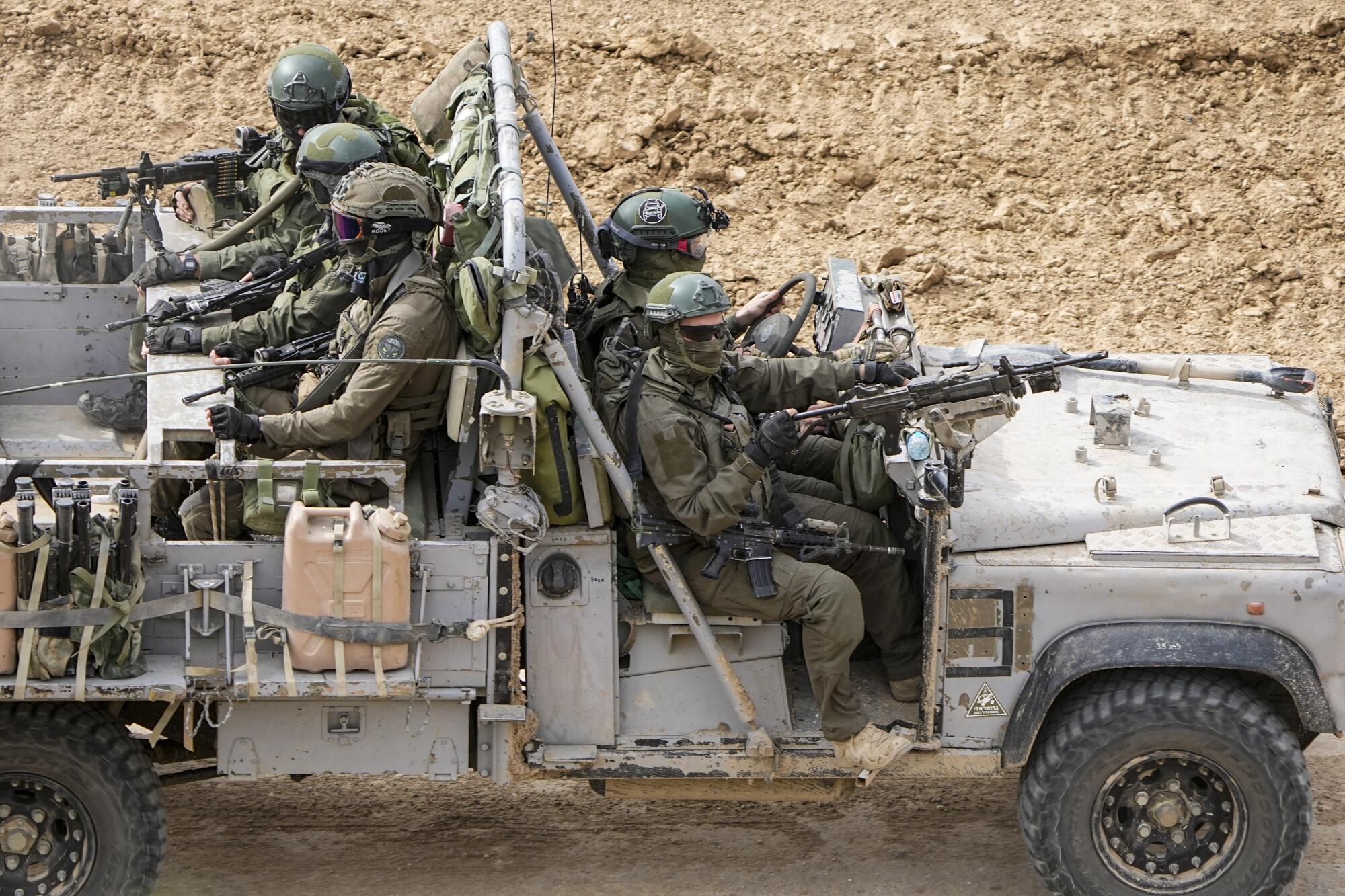 Israeli soldiers drive towards the Gaza Strip, in southern Israel, Tuesday,