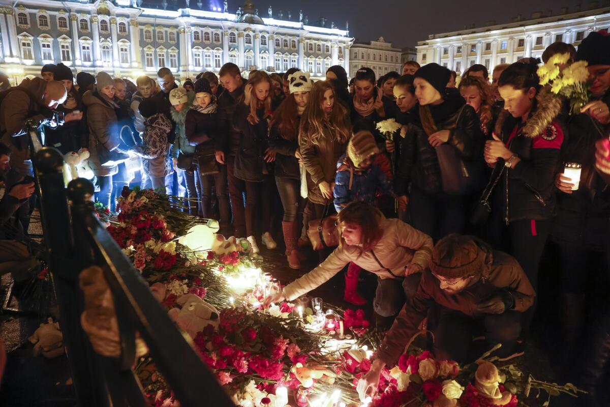 Un grupo de personas enciende velas durante el día de luto oficial por las víctimas de un accidente de avión, en su mayoría rusos, en la península egipcia del Sinaí, en la plaza del palacio Dvortsovaya, en San Petersburgo, Rusia, el 1 de noviembre de 2015. (Foto AP/Dmitry Lovetsky)