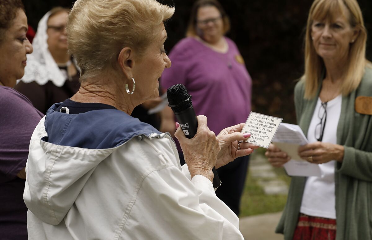 Volunteer Pat Goscienski reads the names of children