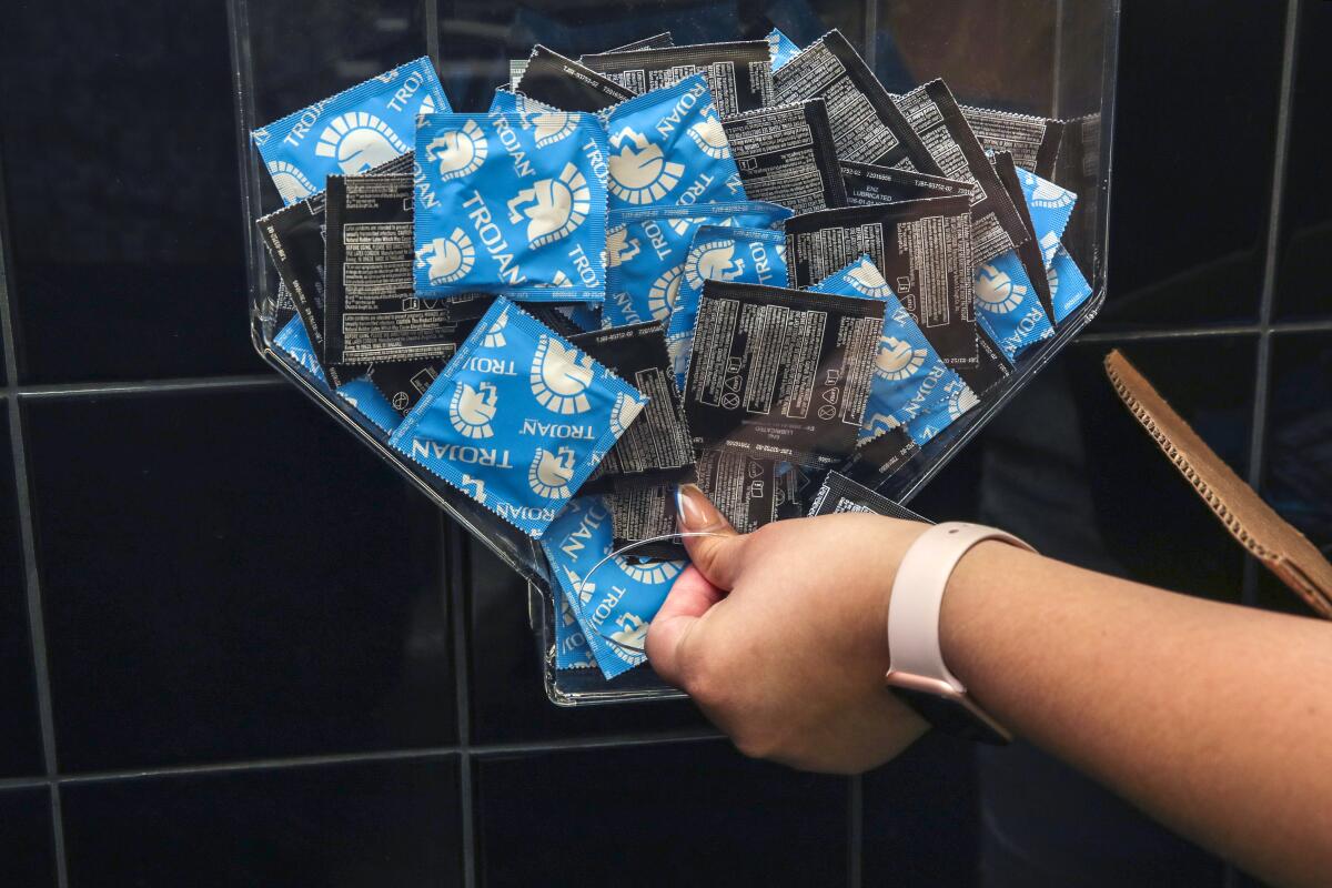 A condom dispenser is restocked at the San Diego State campus in Calexico.