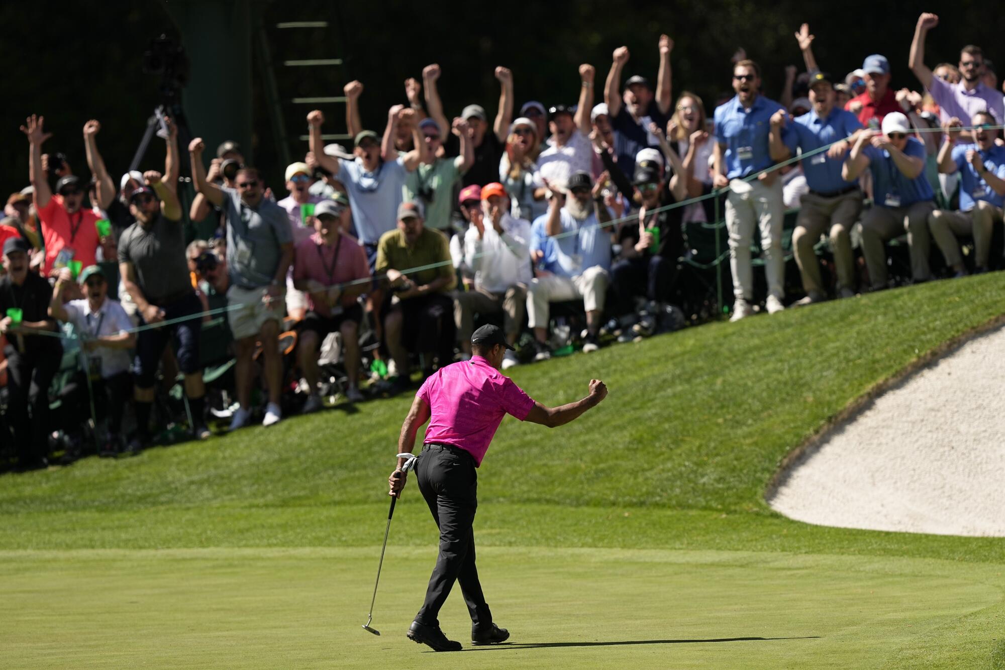 Tiger Woods pumps his fist after a birdie putt on the 16th green.