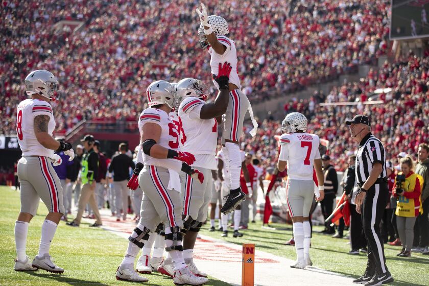 Ohio State's Thayer Munford, center, lifts Chris Olave, center right, after he scored a touchdown against Nebraska during the first half of an NCAA college football game Saturday, Nov. 6, 2021, at Memorial Stadium in Lincoln, Neb. Also on hand for the celebration were Kamryn Babb (8) and Luke Wypler (53). (AP Photo/Rebecca S. Gratz)
