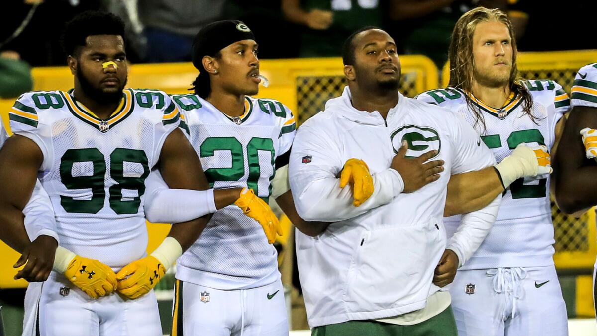 Packers players lock arms during the playing of the national anthem before Thursday night's game against the Bears.