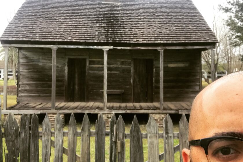 Clint Smith stands in front of an original slave cabin at the Whitney Plantation in New Orleans.