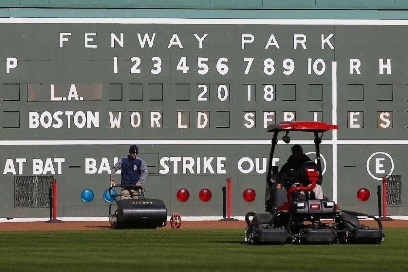 Mandatory Credit: Photo by MATT CAMPBELL/EPA-EFE/REX (9940500e) Groundskeepers mow the outfield grass in front of the famed 'Green Monster' a day before the start of the baseball World Series between the Boston Red Sox and the Los Angeles Dodgers at Fenway Park in Boston, Massachusetts, USA, 22 October 2018. The best-of-seven series to determine Major League Baseball's champion will feature, as necessary, games one, two, six and seven in Boston, Massachusetts and games three, four and five in Los Angeles, California. Baseball World Series, Boston, USA - 22 Oct 2018 ** Usable by LA, CT and MoD ONLY **