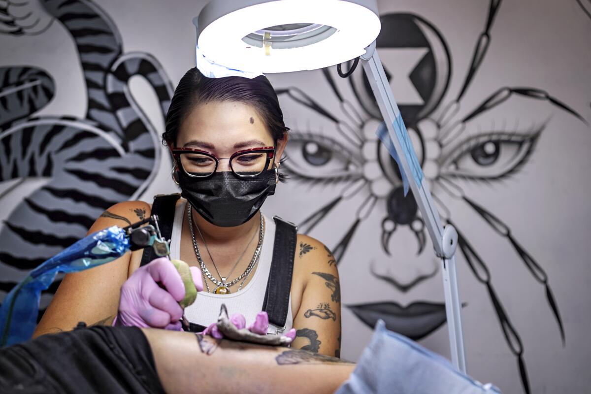 Tattoo artist Emily Kay gives Sydney Kramer her latest tattoo at Strangelove in Echo Park.