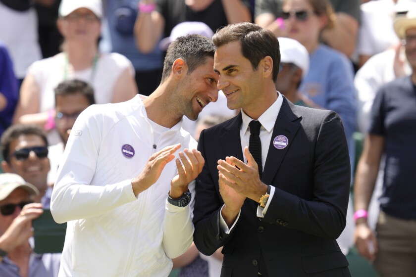 Serbia's Novak Djokovic and Switzerland's Roger Federer speak during a 100 years of Centre Court celebration on day seven of the Wimbledon tennis championships in London, Sunday, July 3, 2022. (AP Photo/Kirsty Wigglesworth)