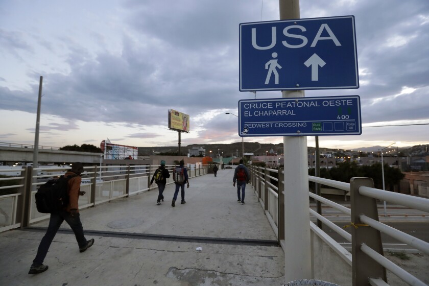 FILE - In this Sept. 27, 2016 file photo, Haitians make their way towards the border crossing in Tijuana, Mexico. The Trump administration is planning to expand the collection of DNA from migrants who cross the U.S. border, and to include the information in a massive criminal database operated by the FBI (AP Photo/Gregory Bull, file)