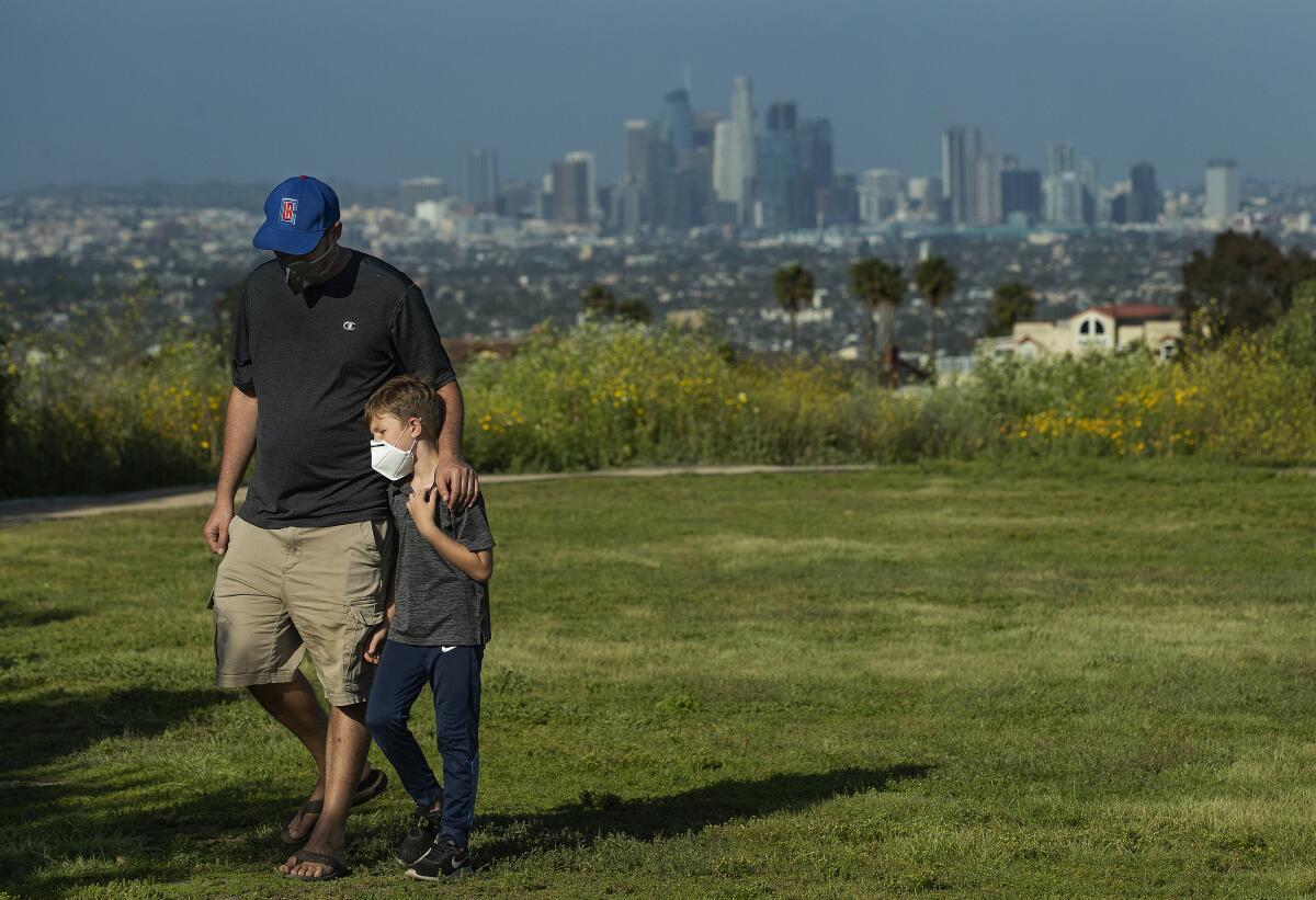 Lee Bloom, 39, of Los Angeles and his son Evan, 7, wear protective masks