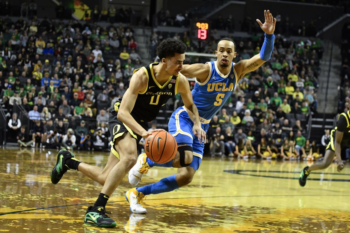 Will Richardson de l'Oregon se dirige vers le panier alors qu'Amari Bailey de l'UCLA applique une pression au cours de la première mi-temps le 11 février 2023.