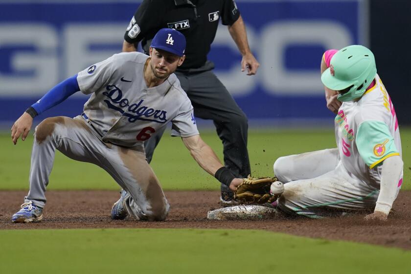 Los Angeles Dodgers shortstop Trea Turner can't make the catch as San Diego Padres' Wil Myers steals.