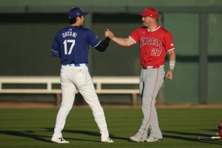 Los Angeles Dodgers designated hitter Shohei Ohtani (17) greets Los Angeles Angels center fielder Mike Trout (27) before a spring training baseball game in Phoenix, Tuesday, March 5, 2024. (AP Photo/Ashley Landis)