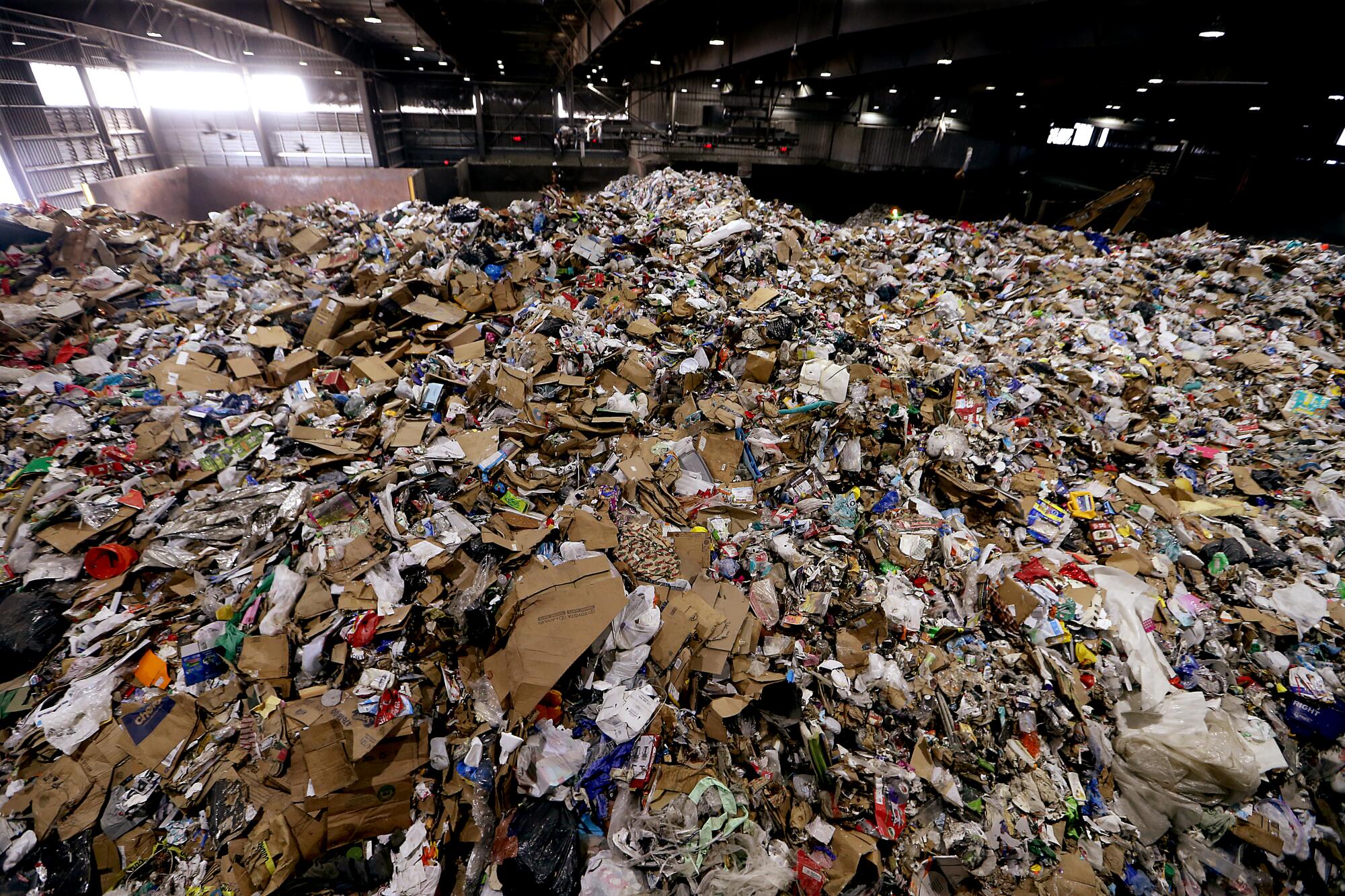 A huge mountain of trash is piled up inside the cavernous Athens material recovery facility in Sun Valley.