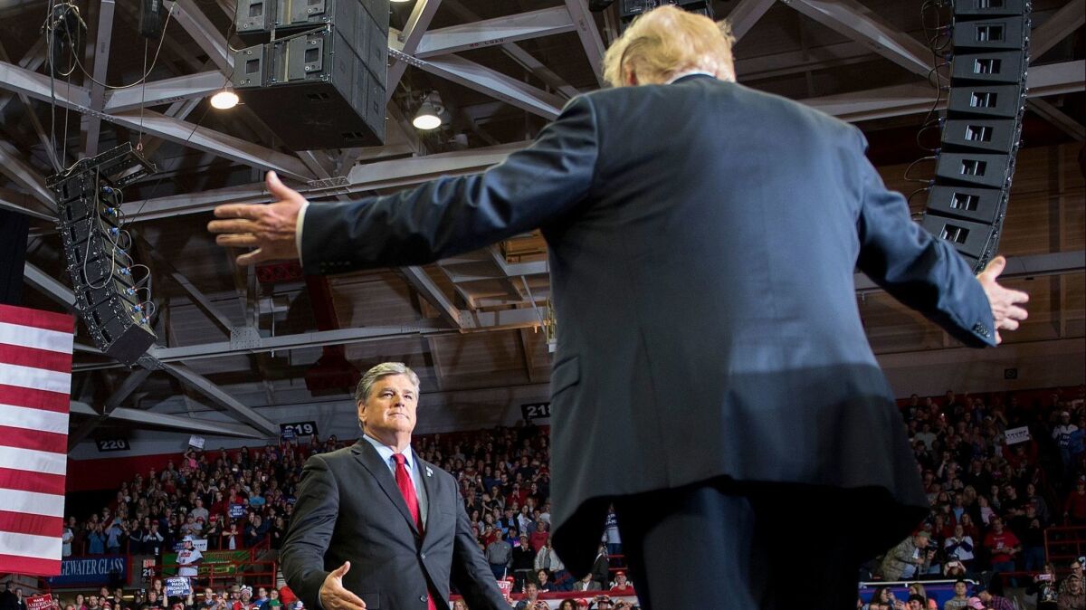President Donald Trump greets Fox News host Sean Hannity at a rally in Cape Girardeau, Missouri, on Nov. 5, 2018.