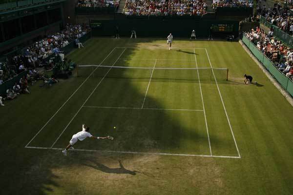 John Isner (DOWN) returns a ball to Nicolas Mahut during the Wimbledon Tennis Championships on June 23, 2010.
