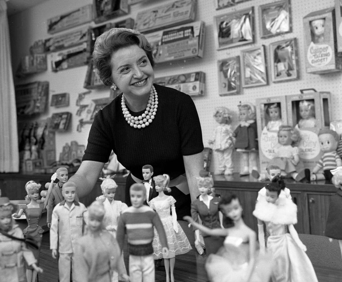 Ruth Handler, co-founder of Mattel Inc., posing with a collection of Barbie dolls