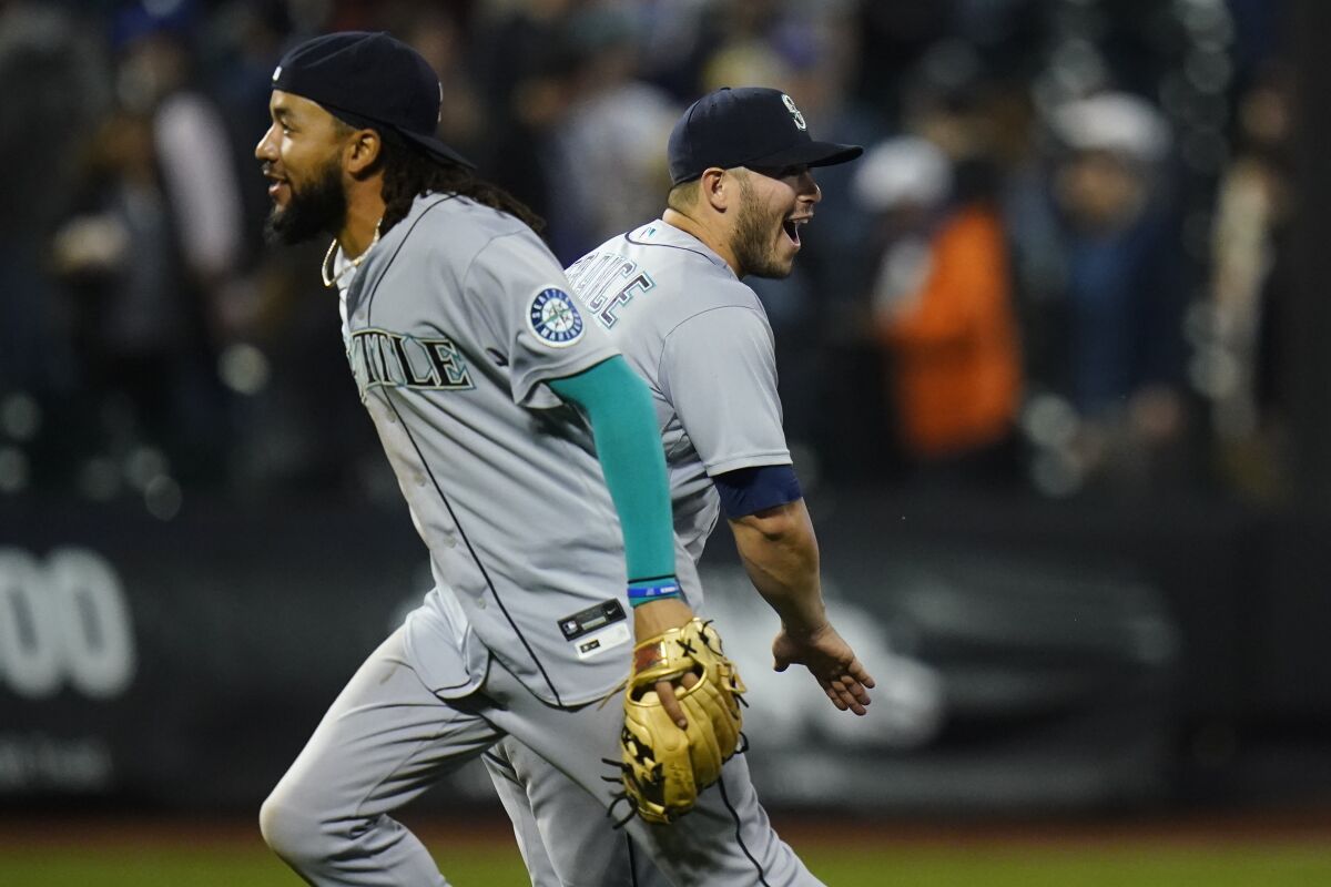 Seattle Mariners' Ty France, right, celebrates with J.P. Crawford after a baseball game against the New York Mets Friday, May 13, 2022, in New York. The Mariners won 2-1. (AP Photo/Frank Franklin II)