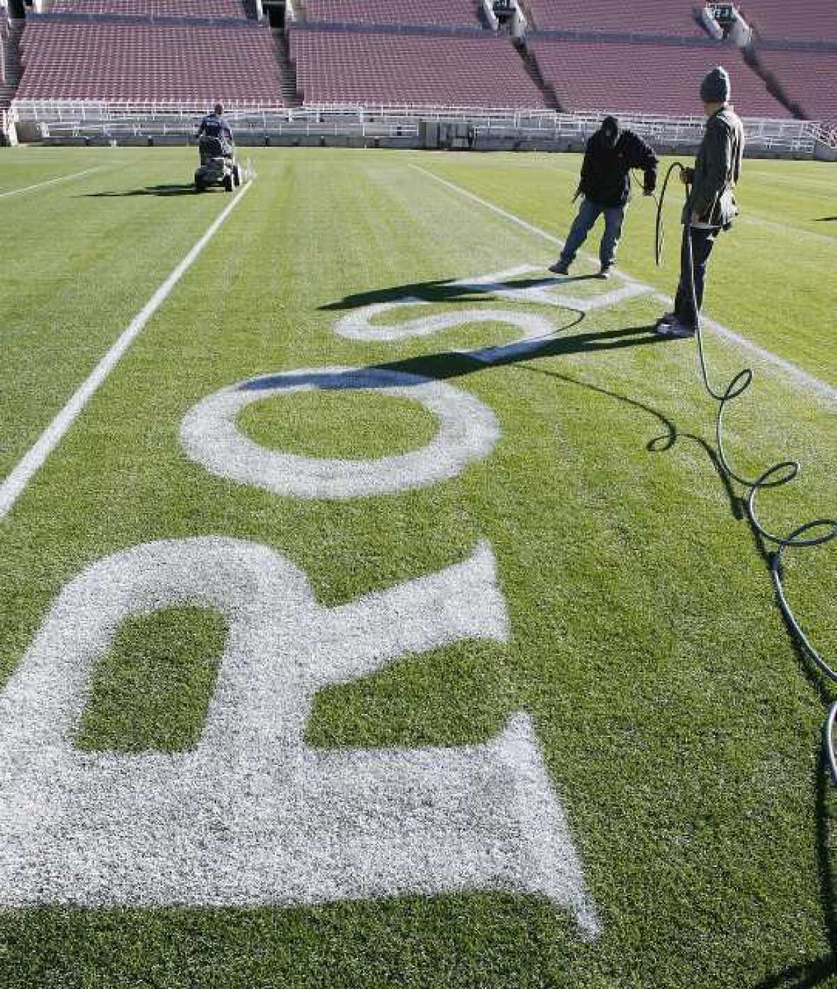 ROSE is painted on the field, part of the artwork at the 50-yard-line, at the Rose Bowl stadium in Pasadena. Everything that goes into preparing for the upcoming Rose Bowl football game takes place on a schedule and behind the scenes.